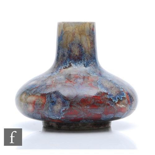 132 - Ruskin Pottery - A high fired vase of compressed form decorated with a snakeskin type glaze in tones... 