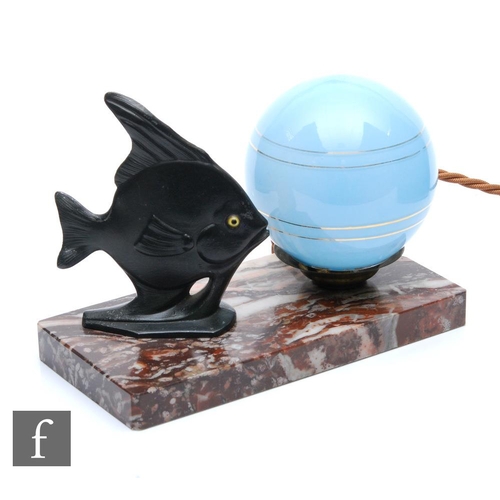 575 - Unknown - A small 1930s Art Deco lamp, the rectangular marble base with a metal fish beside a blue g... 