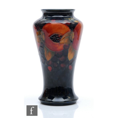 155 - William Moorcroft - A vase of tapering form decorated in the Pomegranate pattern with a band of open... 