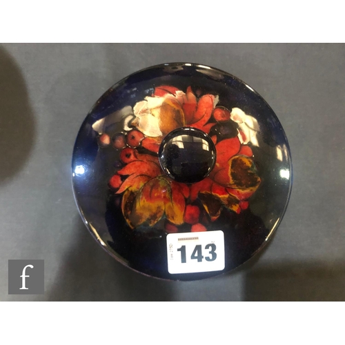 143 - William Moorcroft - A small bowl and cover decorated in the Flambe Leaf and Berry pattern, impressed... 