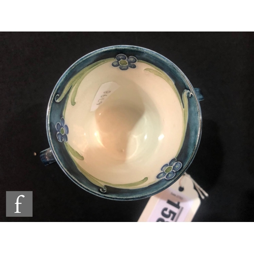 158 - William Moorcroft - James Macintyre & Co - A small twin handled loving cup decorated with blue p... 