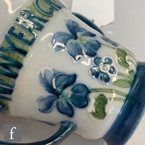 158 - William Moorcroft - James Macintyre & Co - A small twin handled loving cup decorated with blue p... 