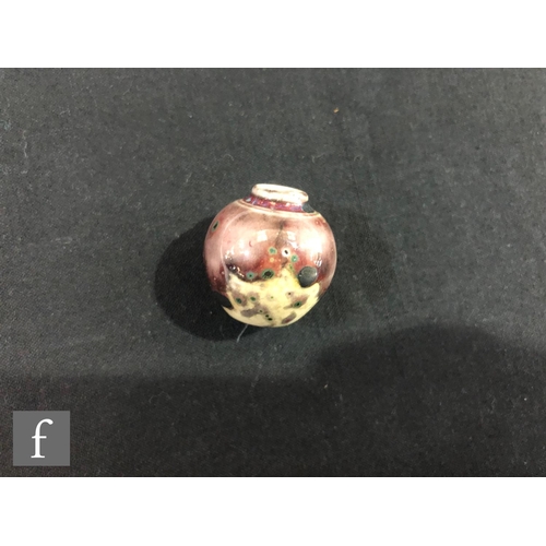 130 - Ruskin Pottery - A high fired miniature vase of globular form decorated in a sweeping tonal purple g... 