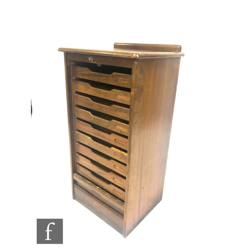 1327 - A 1930s mahogany nine drawer filing cabinet enclosed by a vertical e slide below a ledge back, heigh... 