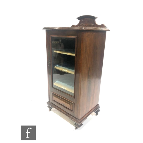 1321 - An Edwardian mahogany serpentine fronted music cabinet, the fitted shelf interior enclosed by a glaz... 