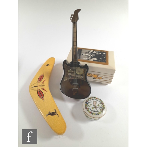 1089 - A novelty musical bass guitar in black plastic with stand, an Elvis Presley musical cigarette box, a... 