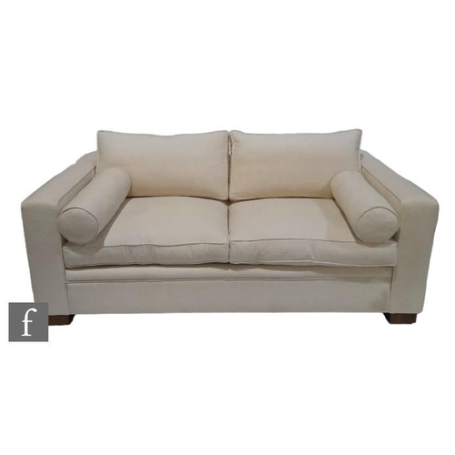 1324 - A David Linley Chase two seater sofa, the cream fabric sofa raised on wooden block feet, with Linley... 