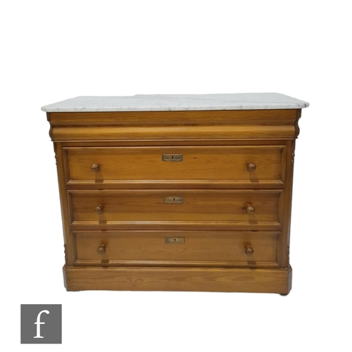 1310 - A Biedermeier style pine chest of three drawers below a white marble top, turned wood handles, cante... 