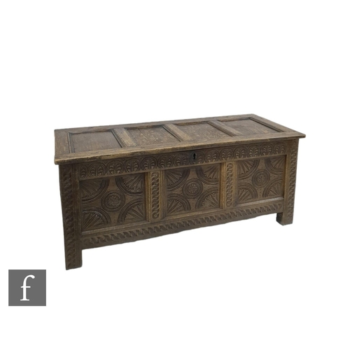 1313 - An 18th Century oak triple panelled coffer, the conforming front below a lunette style frieze on sti... 