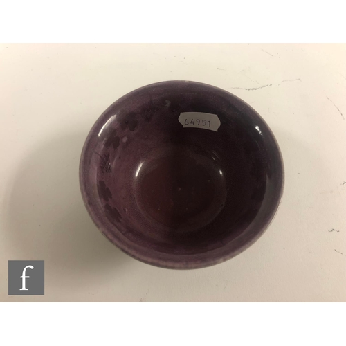 144 - A Ruskin Pottery souffle glaze bowl, the whole in purple with a painted vine garland to the interior... 