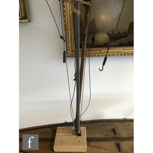 558 - A 1940s or later model pond yacht on wooden stand with beam, length 74cm, a similar single masted ya... 