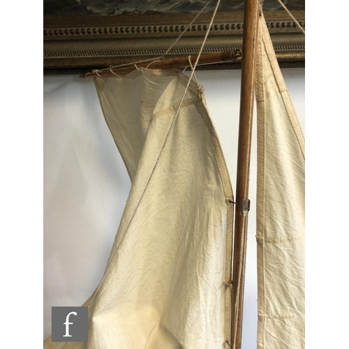 558 - A 1940s or later model pond yacht on wooden stand with beam, length 74cm, a similar single masted ya... 