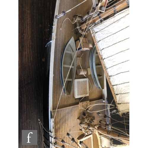 558 - A 1940s or later model pond yacht on wooden stand with beam, length 74cm, a similar single masted ya... 