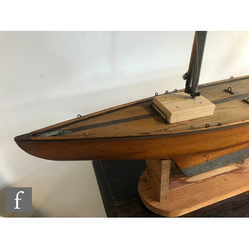 558 - A 1940s or later model pond yacht on wooden stand with beam, length 74cm, a similar single masted ya... 