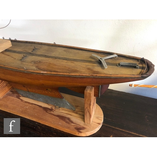 558 - A 1940s or later model pond yacht on wooden stand with beam, length 74cm, a similar single masted ya... 