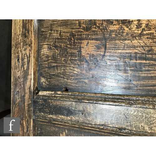 1313 - An 18th Century oak triple panelled coffer, the conforming front below a lunette style frieze on sti... 