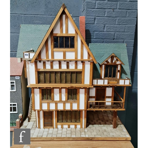 1185 - A large dolls house modelled as a Tudor house, three storeys with attic, with external staircase and... 