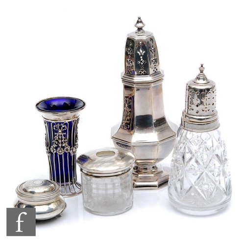 115 - Five items of hallmarked silver, two sugar castors, a hair tidy, a small vase and a trinket box, var... 