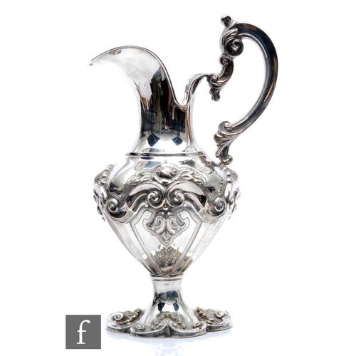 119 - A Portuguese silver plated ewer, shaped circular foot with embossed shell decoration, below part fol... 