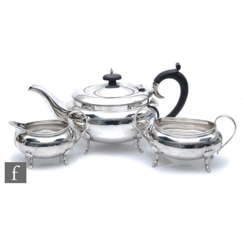 128 - A hallmarked silver three piece boat shaped tea set of plain form, total weight 34oz, terminating in... 