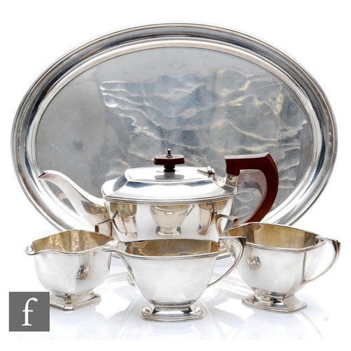 13 - An Art Deco style hallmarked silver pedestal  boat shaped three piece tea set of plain form with ree... 