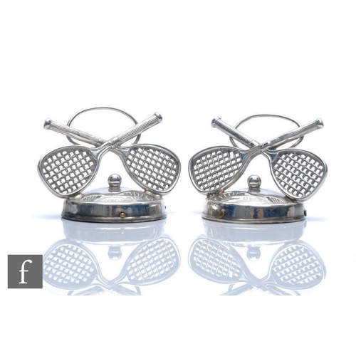 160 - A pair of hallmarked silver menu holders each modelled as a pair of cross tennis rackets with a sing... 