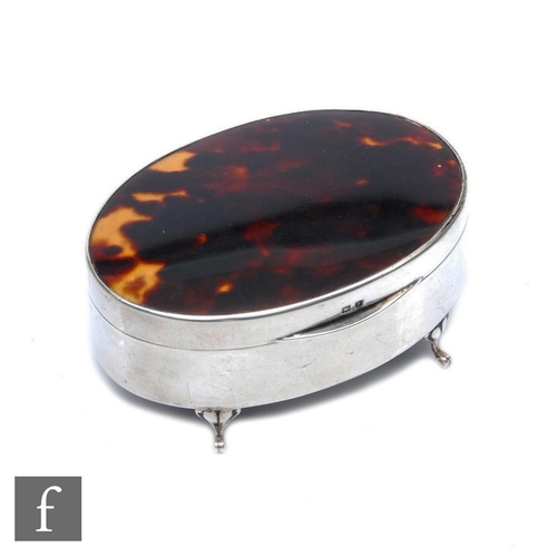 169 - A hallmarked silver oval trinket box with tortoiseshell panel to hinged cover, all raised on four sc... 