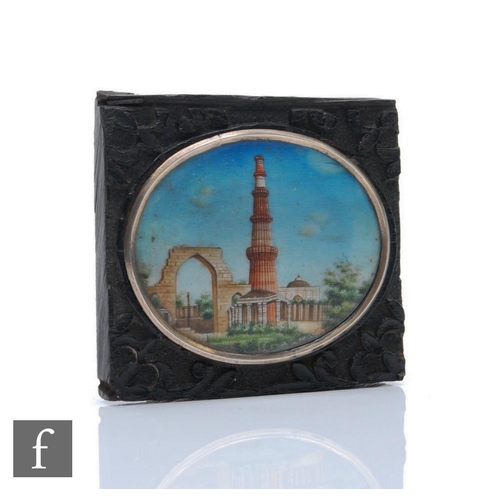 173 - A 19th Century Indian School oval miniature depicting temple ruins, width 5cm, to a hard wood mount ... 