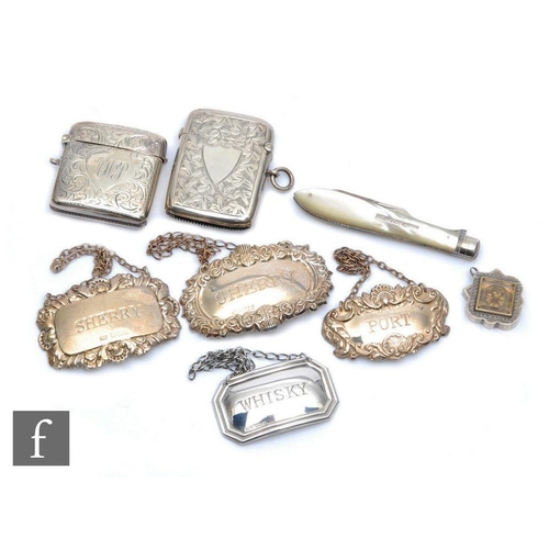 174 - A small parcel lot of hallmarked silver items four assorted decanter labels, two vesta cases, a comp... 