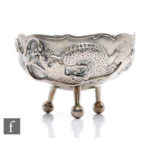 19 - An early 20th Century Chinese style silver circular bowl decorated with a scrolling dragon and raise... 