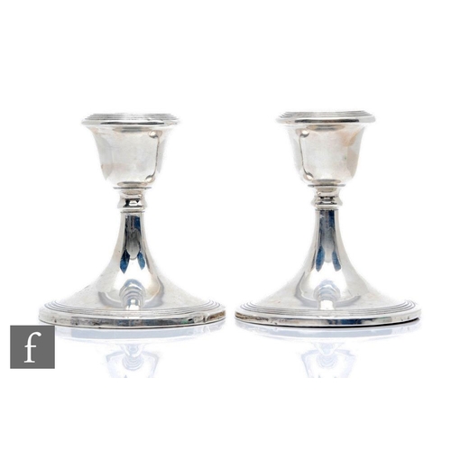 23 - A pair of hallmarked silver piano candlesticks each with reeded detail to circular foot and sconce, ... 