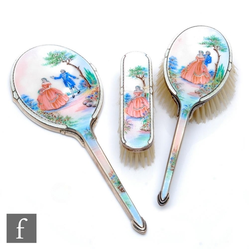 24 - A hallmarked silver and enamelled three piece brush set decorated with a courting couple in a landsc... 