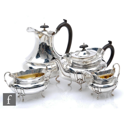 31 - A hallmarked silver four piece, boat shaped tea set each raised on four scroll feet with stylised fl... 