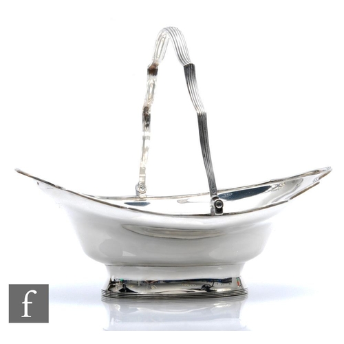 37 - A hallmarked silver pedestal boat shaped swing basket of plain form terminating in reeded waved bord... 