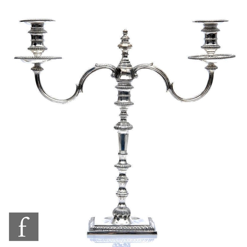 47 - A hallmarked silver twin light cast candelabra, square base with gadroon detail to border below doub... 