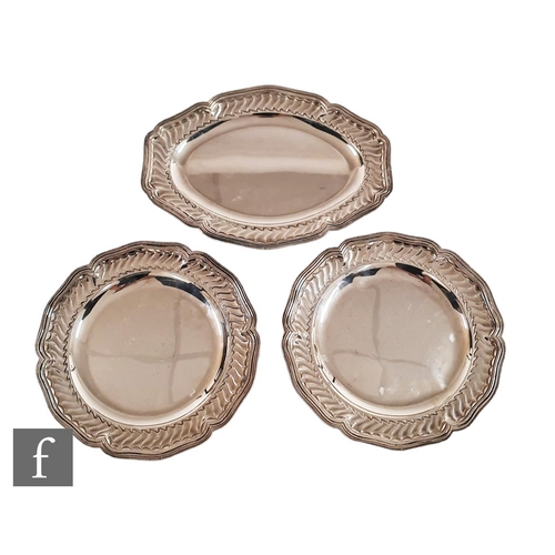 64 - Two modern silver circular plates, each with fluted scroll detail within hexagonal scalloped borders... 