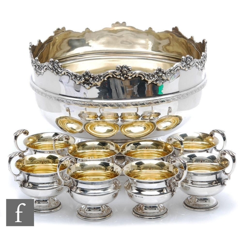 74 - A hallmarked silver punch bowl of plain form with stepped circular base and terminating in floral wa... 