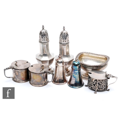 8 - Eight assorted hallmarked silver condiments to include two pairs of peppers, two drum mustard pots e... 