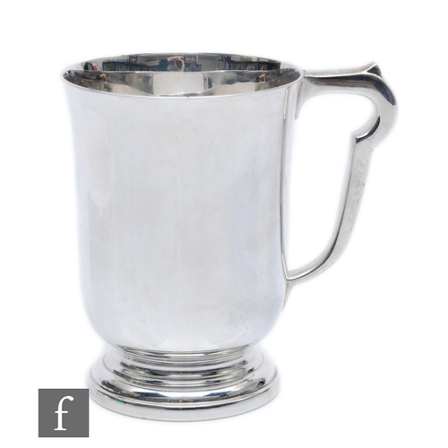 86 - A hallmarked silver tankard of circular stepped base below plain flaring body, weight 10.5oz, height... 