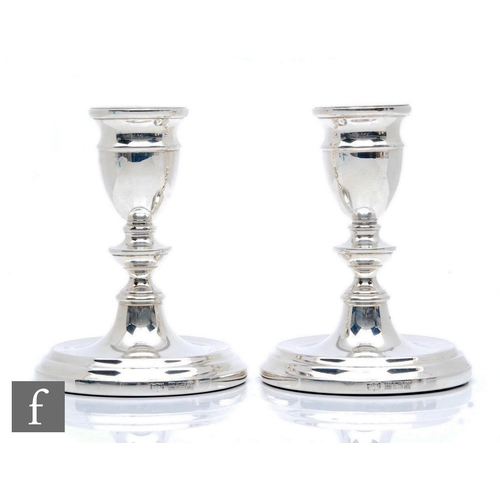 88 - A pair of hallmarked silver piano candlesticks, circular bases below knop columns and conforming sco... 