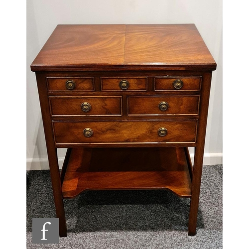 141 - A contemporary Reprodux mahogany canteen table, with hinged fold-over top and three drawers, fitted ... 