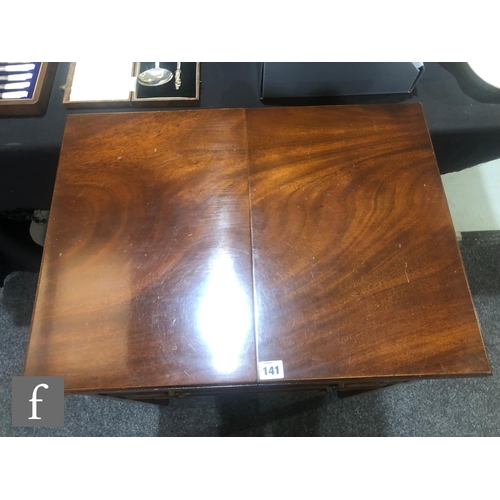 141 - A contemporary Reprodux mahogany canteen table, with hinged fold-over top and three drawers, fitted ... 