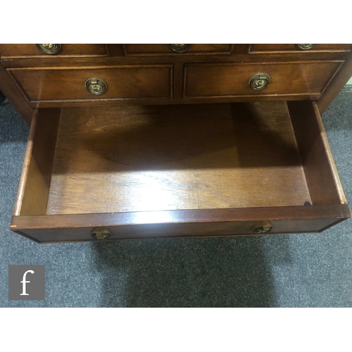 141 - A contemporary Reprodux mahogany canteen table, with hinged fold-over top and three drawers, fitted ... 