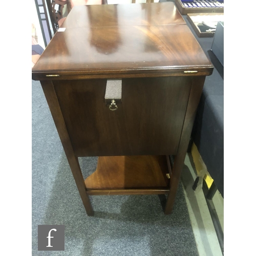 141 - A contemporary Reprodux mahogany canteen table, with hinged fold-over top and three drawers, fitted ... 