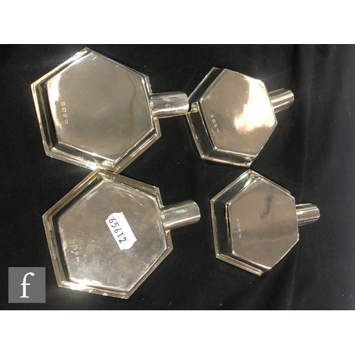 175 - A hallmarked silver hexagonal shaped table lighter with scroll handle and four conforming ashtrays, ... 