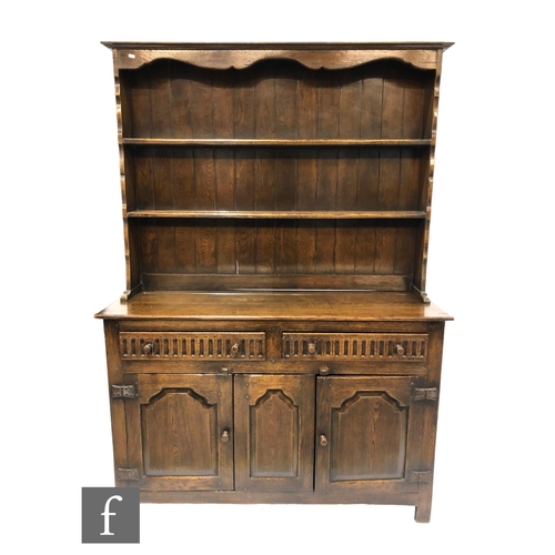 1039 - A 17th Century style oak dresser fitted with two lunette drawers over three fielded panel doors on s... 