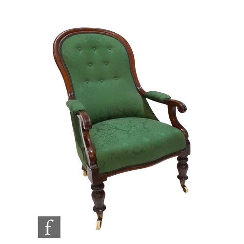 985 - A Victorian mahogany spoon back easy chair on turned legs to the front, upholstered in green buttone... 