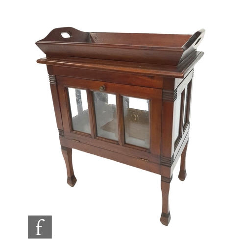 988 - An Edwardian style floorstanding drinks cabinet fitted with a loose tray on a bevelled glass panelle... 