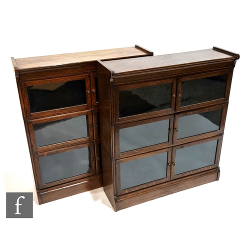 1007 - A pair of oak bookcases in the manner of Minty, each fitted with three glazed double doors over a pl... 