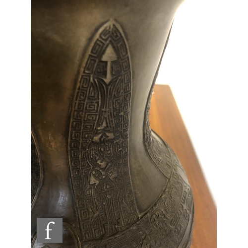 141 - A Chinese cast metal archaic vase, Hu, rising from a high footring and applied with two loop and rin... 